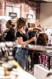 coiffeuse blonde qui fait un brushing